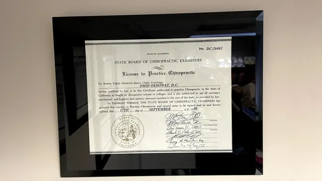 Framed License to Practice Chiropractic on the wall of Dr. Okhowat's office