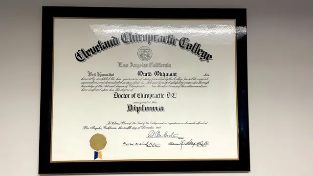Dr. Okhowat's framed Cleveland Chiropractic College diploma on the office wall