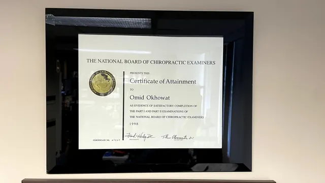 National Board of Chiropractic Examiners certificate framed in black on the office wall