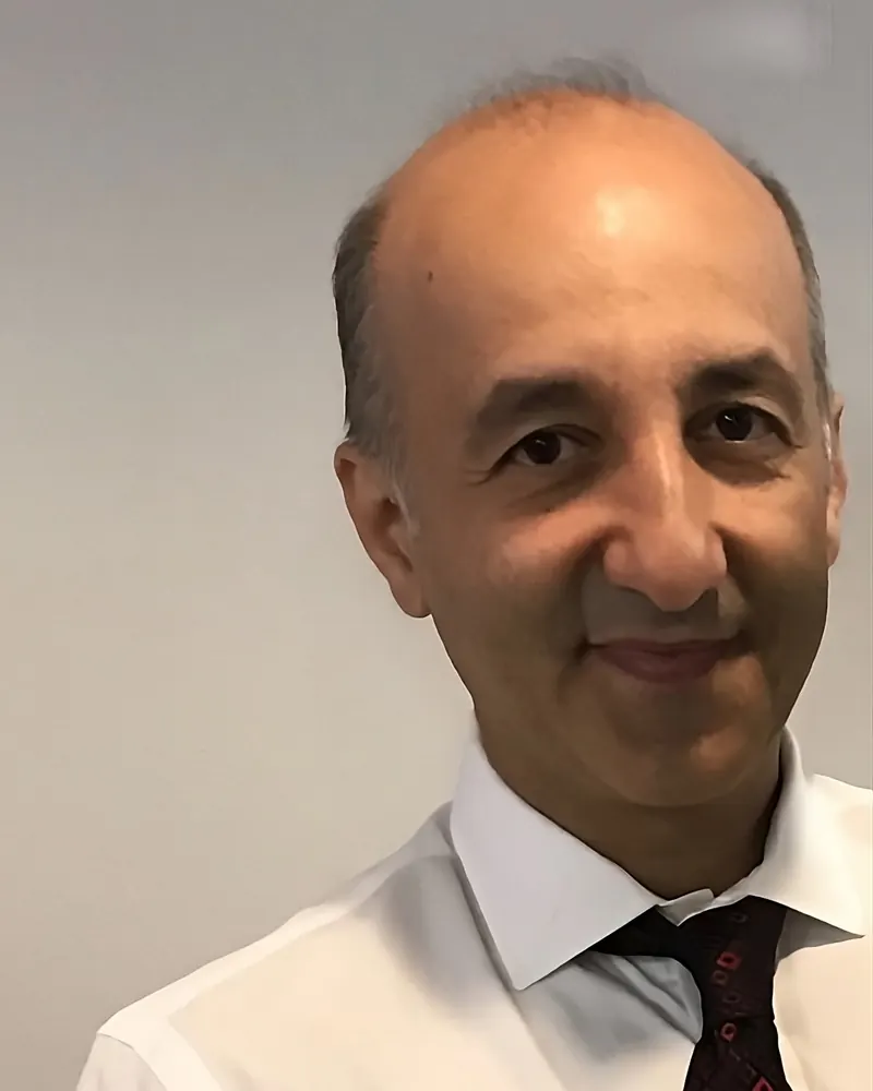 Portrait of Dr. Omid Okhowat, DC, in a white shirt and burgundy tie